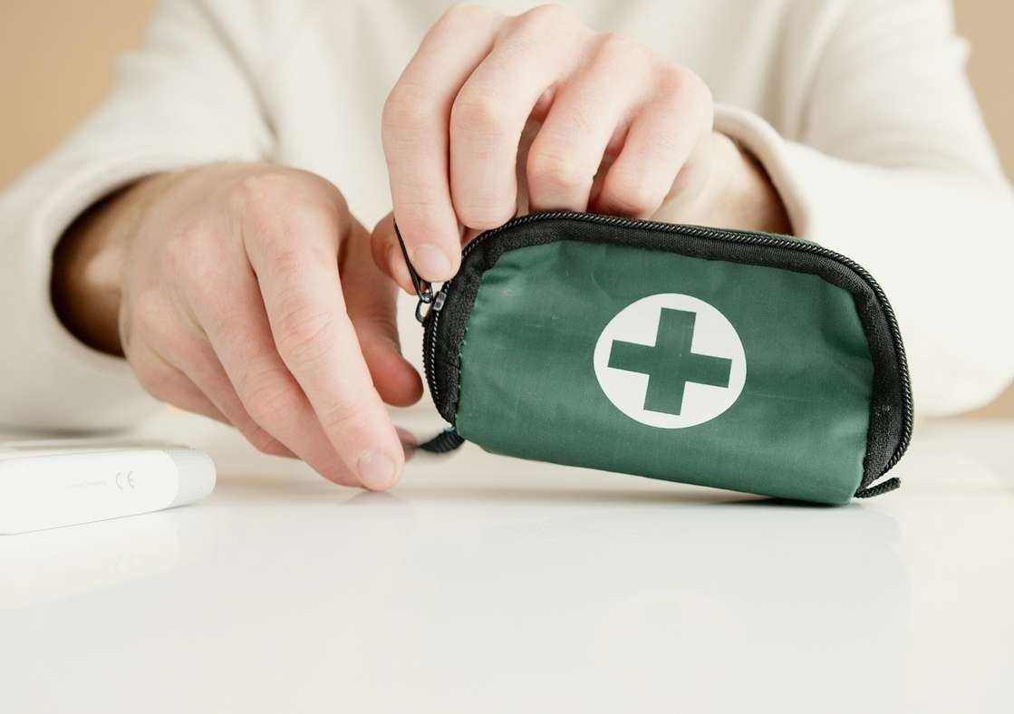 Close-up image of hands holding a first aid pouch on a table