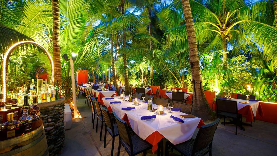Tables lit under the palm grove at Coco Bistro in Grace Bay