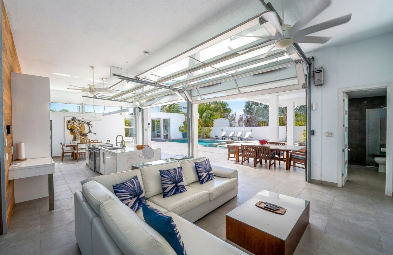 Villa 5 at White Villas: open living room with folding glass doors to the pool terrace